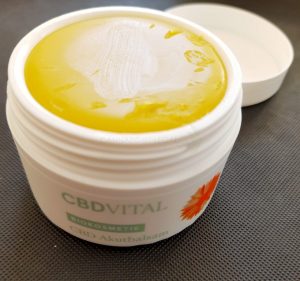 CBD Akutbalsam von CBD VITAL im Test 2020 | Biokosmetik mit CBD-Superkraft 2 Eine offene Dose CBD-Akutbalsam von CBDvital steht auf einen schwarzen Hintergrund